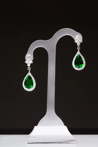 Earrings with green stones on a stand — Stock Photo, Image