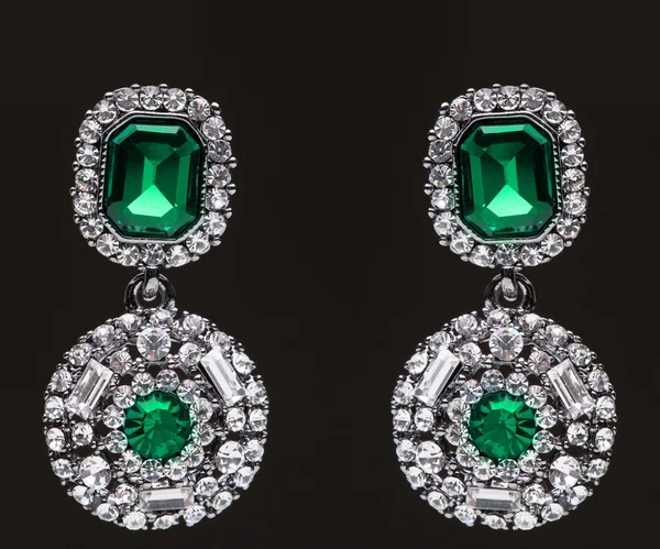 Earrings with green stones on the black — Stock Photo, Image