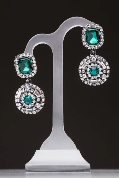 Earrings with green stones on a stand — Stock Photo, Image