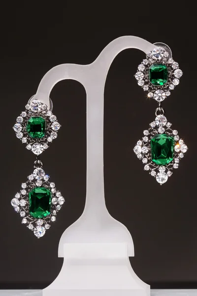 Earrings with green stones on a stand — Stock Photo, Image