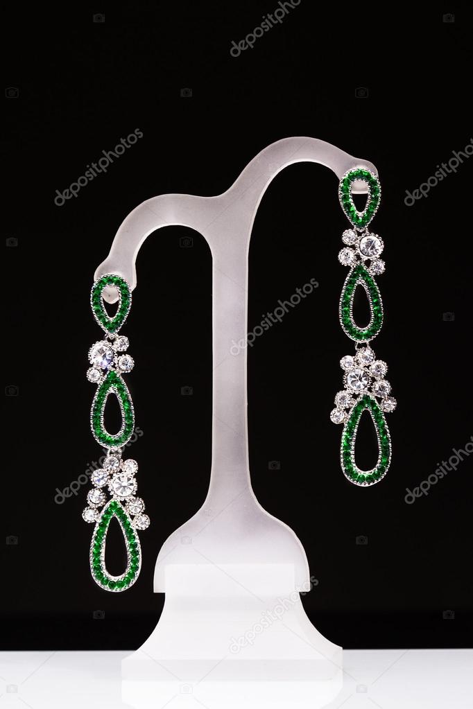earrings with green stones on a stand