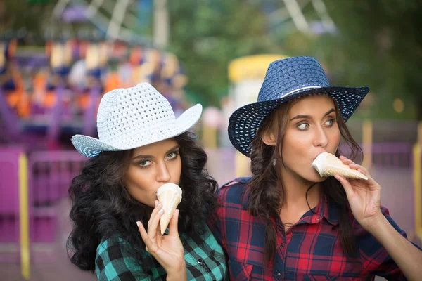 Deux belles filles en chapeaux de cow-boy manger de la crème glacée — Photo