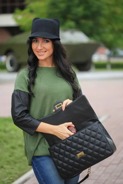 Girl in a hat with ears, holding a bag on the street — Stock Photo, Image