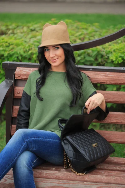 Pige i en hat med ører, holder en taske på gaden - Stock-foto
