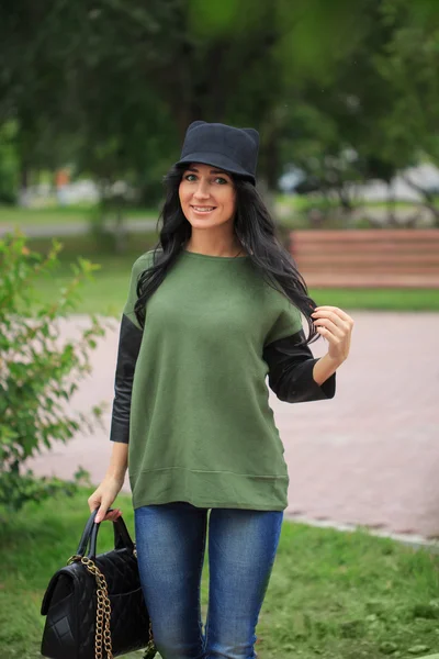 Girl in a hat with ears, holding a bag on the street — Stock Photo, Image