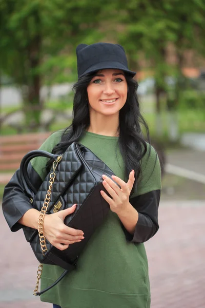 Girl in a hat with ears, holding a bag on the street — Stock Photo, Image