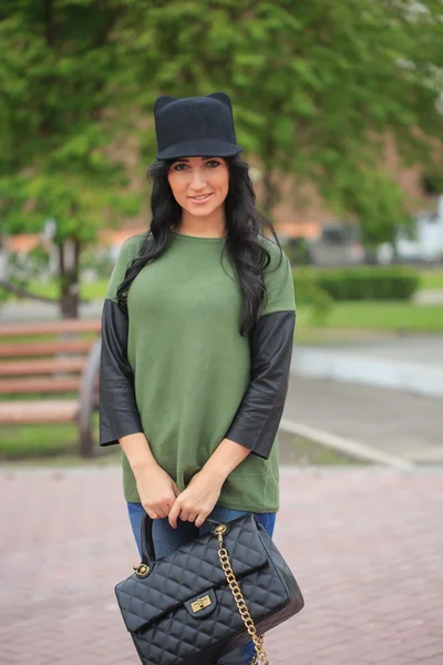 Girl in a hat with ears, holding a bag on the street — Stock Photo, Image