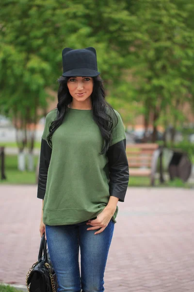 Girl in a hat with ears, holding a bag on the street — Stock Photo, Image