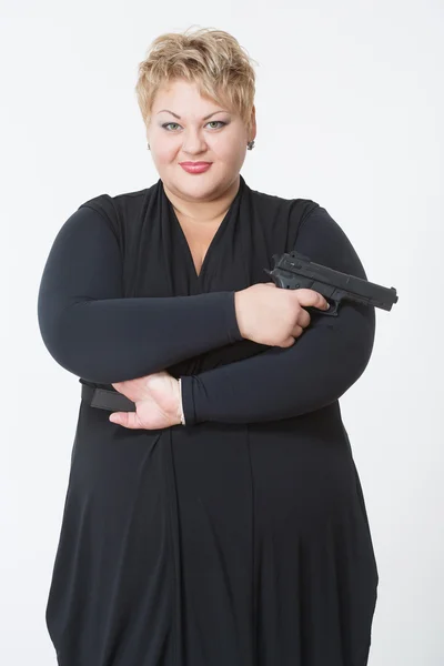 Mujer gorda con un arma. en un vestido negro — Foto de Stock