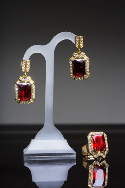 Ohrring und Ring mit bunten roten Edelsteinen — Stockfoto