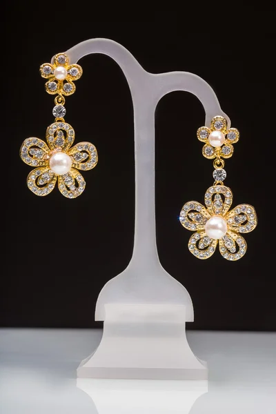 Goldohrringe mit kleinen weißen Steinen. in Form von Blumen — Stockfoto