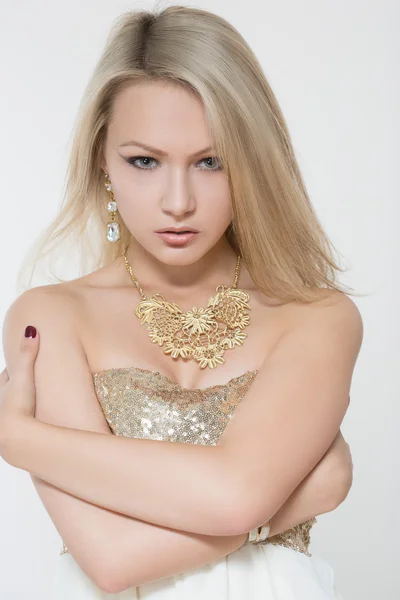 Красивая молодая блондинка. в золотом ожерелье и платье — стоковое фото