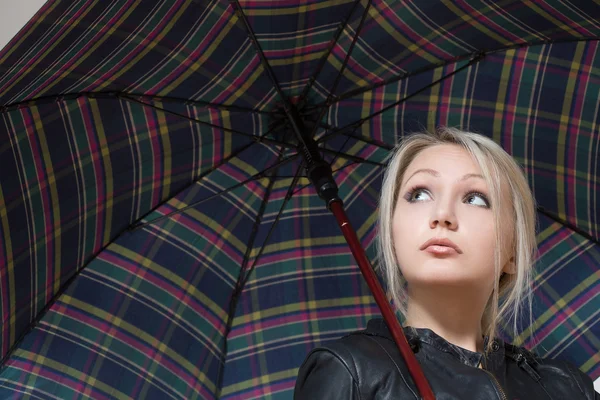 Blonde fille, debout sous un parapluie à carreaux — Photo