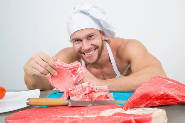 Primer plano del chef en una copa con enormes trozos de carne sobre la mesa — Foto de Stock