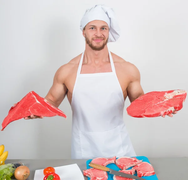 Chef fisiculturista preparar grandes pedaços de carne crua . — Fotografia de Stock