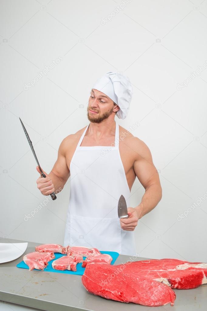 chef bodybuilder preparing large chunks of raw meat.