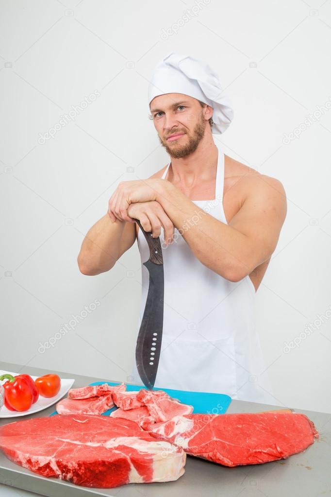 chef bodybuilder preparing large chunks of raw meat.