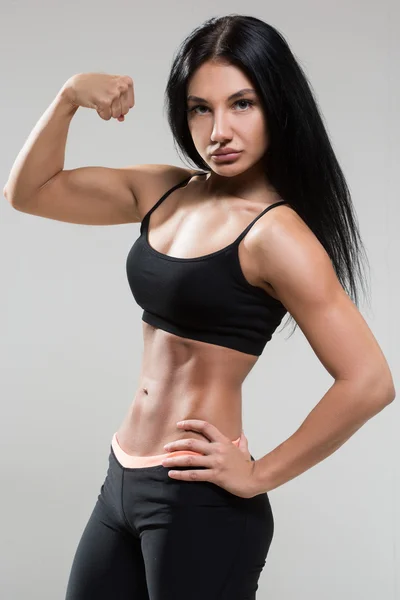 Portrait of young fitness woman shows biceps. — Stock Photo, Image