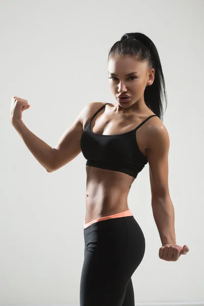 Retrato de joven fitness mujer muestra bíceps . — Foto de Stock