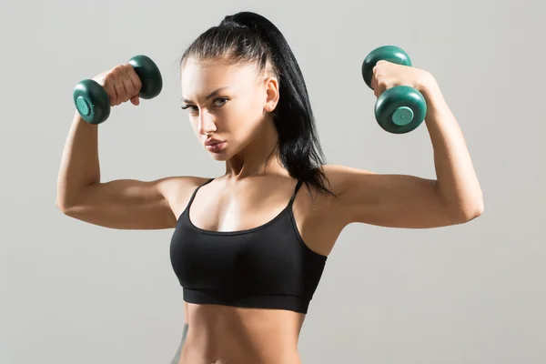 Athletic kvinna pumpa upp muskler med hantlar — Stockfoto