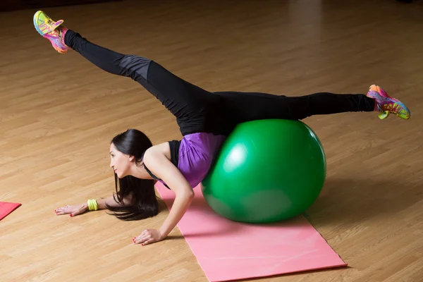 Фитнес-женщина в спортзале отдыхает на пилатесе. Молодая женщина делает упражнения на фитнес-мяч . — стоковое фото