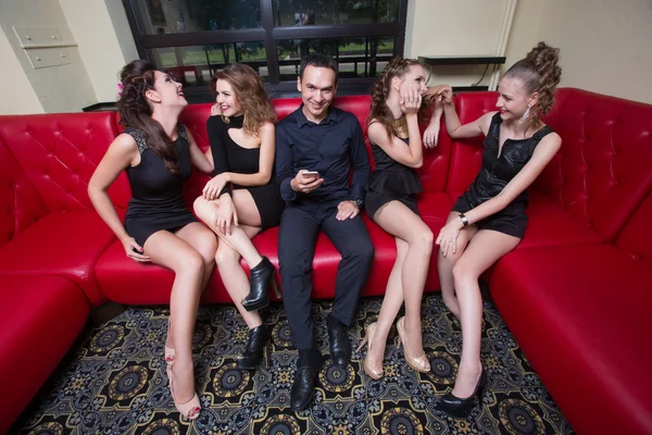 A man holding a cell phone. next four girls. — Stock Photo, Image
