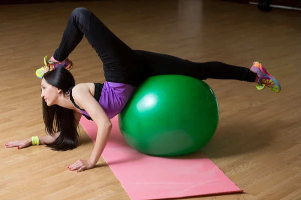 Fitness-Frau im Fitnessstudio auf Pilates-Ball. junge Frau turnt auf Fitnessball. — Stockfoto