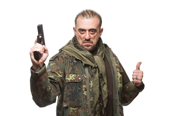 Un homme terroriste vêtu d'une veste militaire avec une arme à la main . — Photo