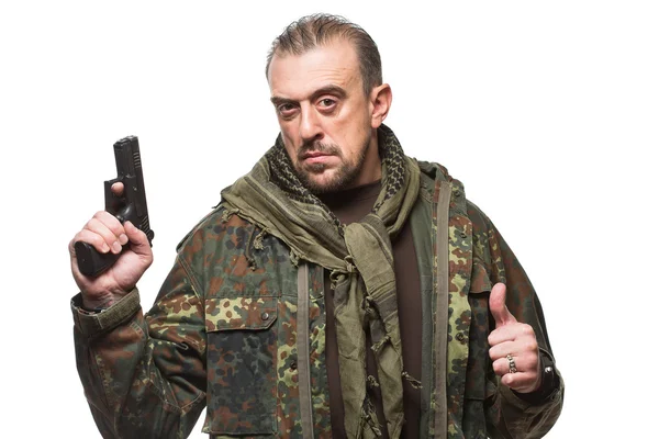 Hombre terrorista en una chaqueta militar con un arma en la mano . — Foto de Stock