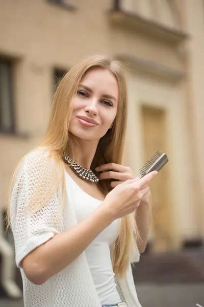 Žena, osvěžující účes v městské ulici — Stock fotografie