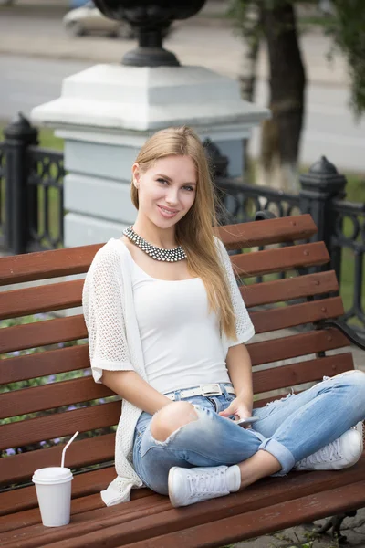 Stylish woman drinking coffee to go in a city street — Stock Photo, Image