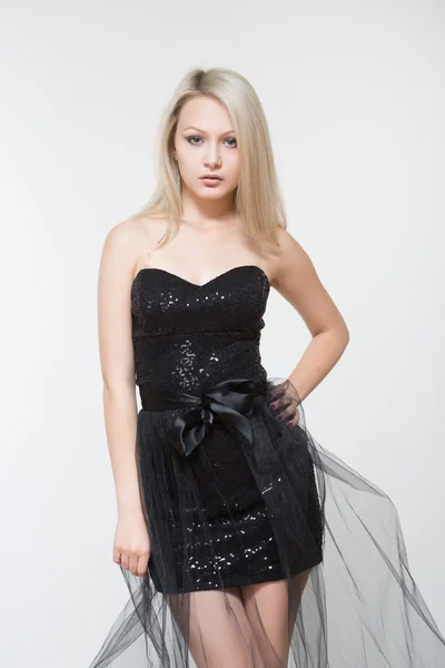 Portrait of beautiful young blonde girl in black dress. — Stock Photo, Image