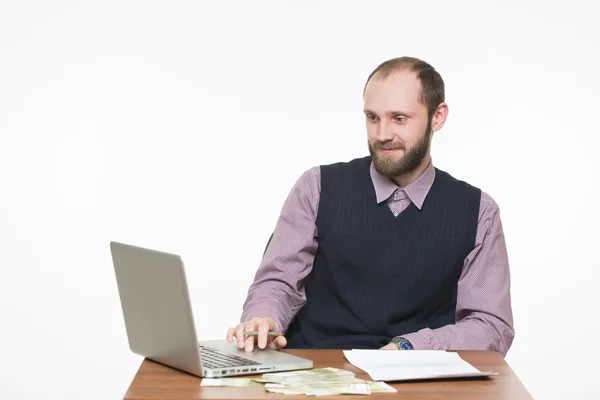 Succesvolle zakenman zitten aan de tafel. Laptop en geld. — Stockfoto