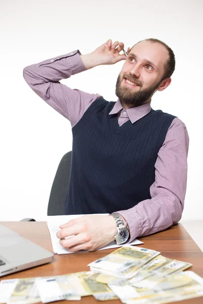 Homem de negócios bem sucedido sentado à mesa. Laptop e dinheiro . — Fotografia de Stock