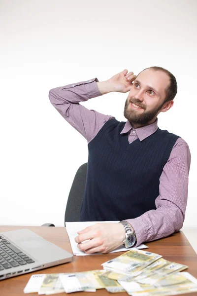 Framgångsrik affärsman sitter vid bordet. Laptop och pengar. — Stockfoto