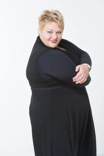 Glimlachend dikke vrouw in zwarte jurk — Stockfoto