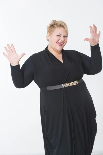 Glimlachend dikke vrouw in zwarte jurk — Stockfoto