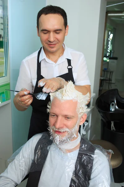 Man repaint het haar in een schoonheidssalon — Stockfoto