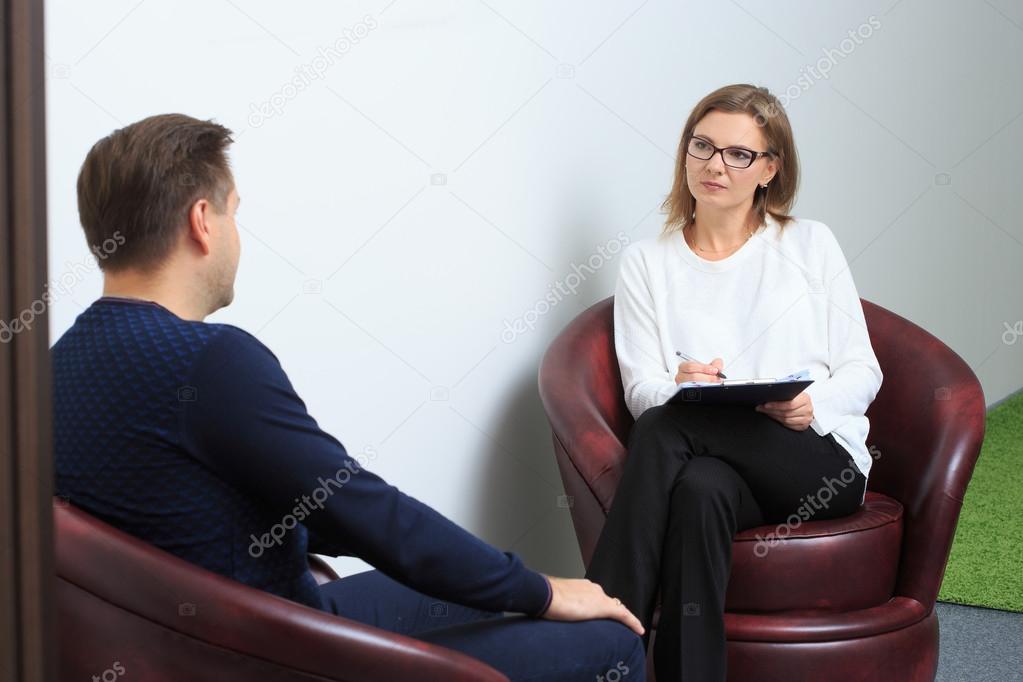psychologist consulting pensive man during psychological therapy session