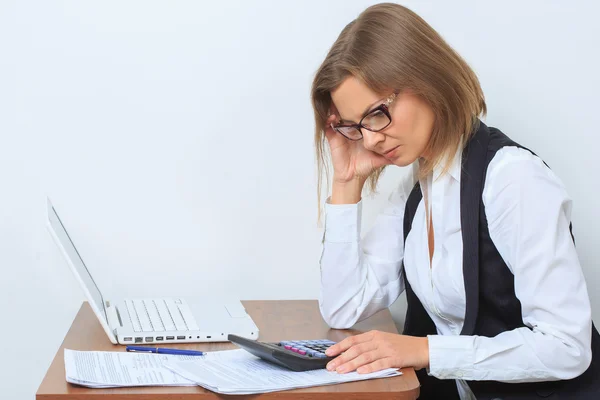 Vrouwelijke beambte zit op haar Bureau en kijk scherm Stockafbeelding