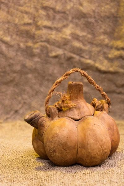 La tetera en forma de la calabaza sobre el fondo de la arpillera — Foto de Stock