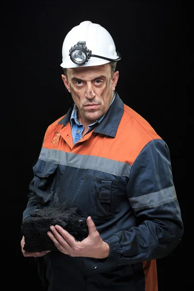 Coalminer holds out a large chunk of energy rich coal — стоковое фото