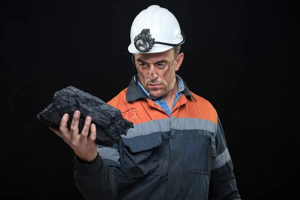 Coalminer holds out a large chunk of energy rich coal — стоковое фото