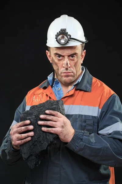 Coalminer holds out a large chunk of energy rich coal — стоковое фото