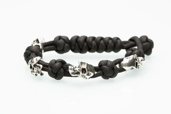 Black braided bracelet with skulls on white background — Stock Photo, Image