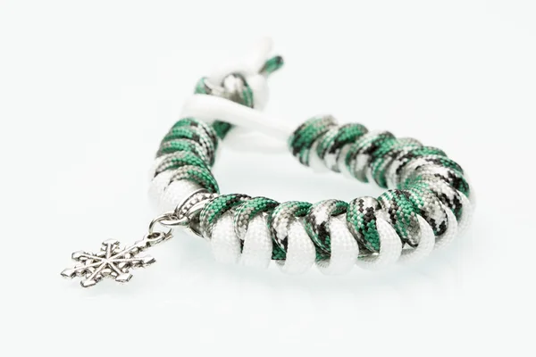 Grünes geflochtenes Armband auf weißem Hintergrund. Schneeflocke — Stockfoto