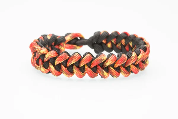 Zwart en oranje gevlochten armband op witte achtergrond — Stockfoto