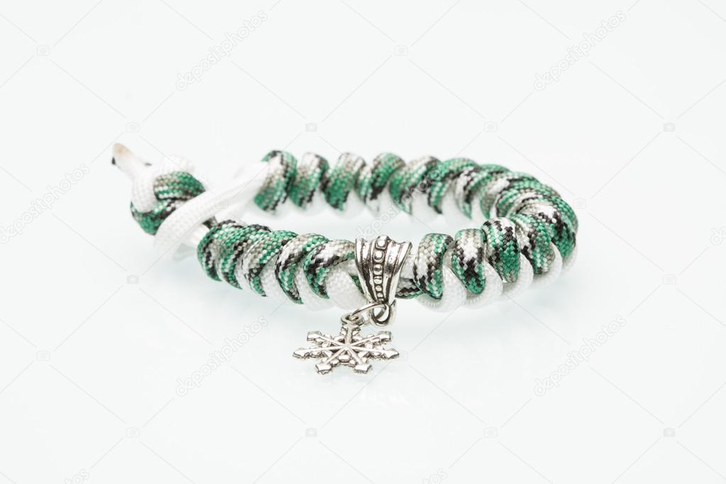green braided bracelet on white background. snowflake