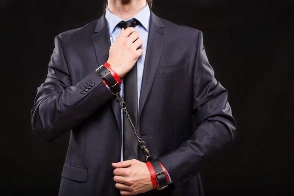 Man in a business suit with chained hands. handcuffs for sex games — Stock Photo, Image