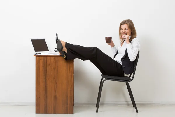 Fille au bureau avec ses pieds sur la table et boire du café. chocolat — Photo